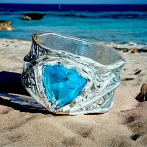 Silver plated ring with comfort band and aquamarine colored stone.
